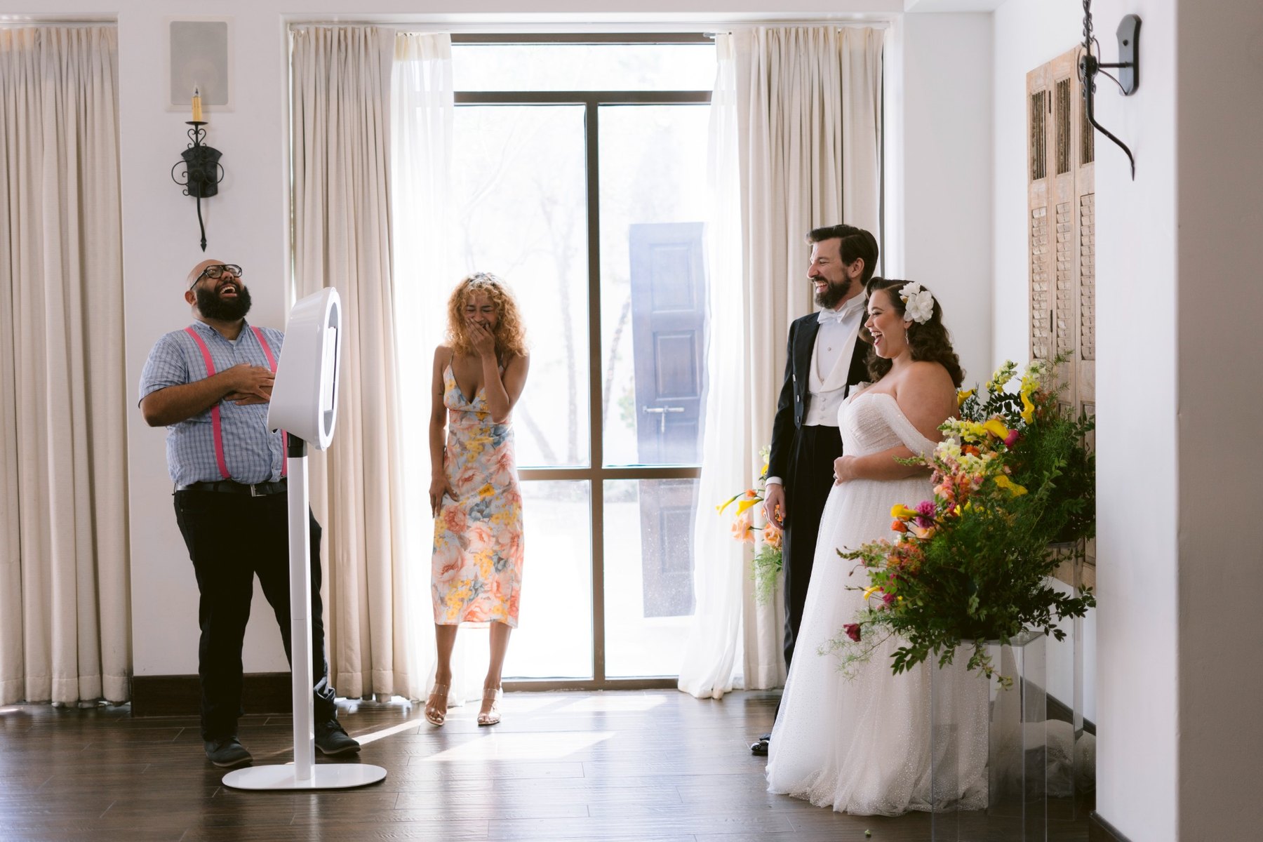 Wedding guests laughing beside the photo booth